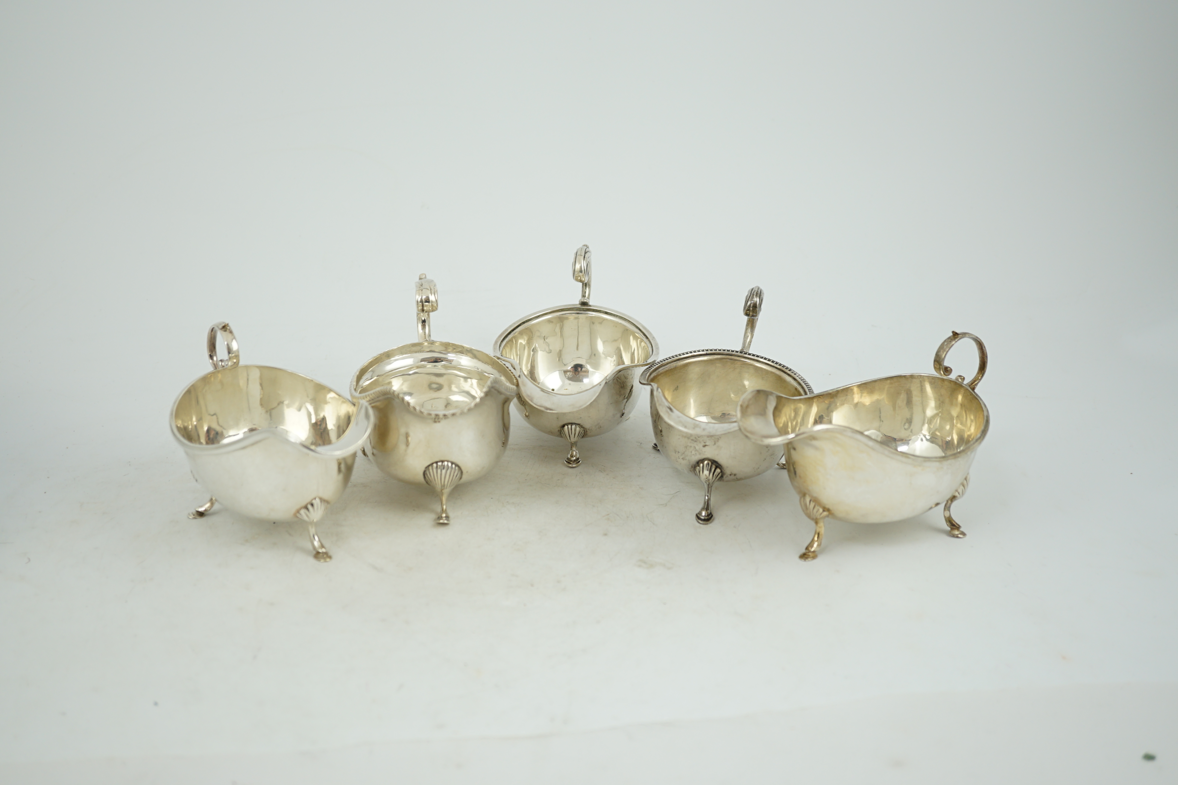 Five assorted early 20th century and later silver sauce boats, various dates and makers, 21.3oz.